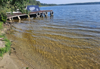 Foto de un embarcadero y agua clara en una cabaña, con vista pintoresca a la orilla de un lago tranquilo.