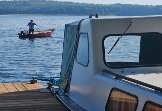 Due barche sul lago vicino al cottage LAWENDA a Grąbczyn, Danimarca, con una persona che pesca.