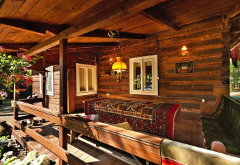 Casetta in legno con veranda accogliente, tappeti e fiori presso Holiday home «Debki» in Svezia.
