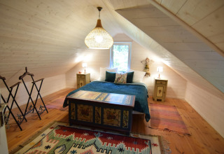 Chambre mansardée chaleureuse avec lit double et tapis colorés au Holiday home «Debki» en Suède.