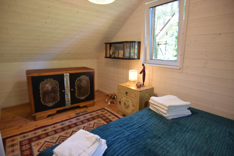 Et hyggeligt soveværelse i Holiday home «Debki» i Sverige, med dekorative møbler og naturligt lys.