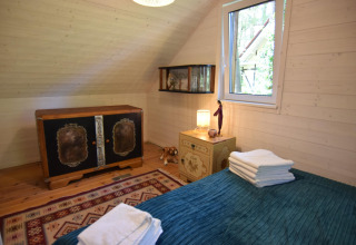 Chambre confortable au Holiday home «Debki» en Suède, avec meubles rétro et lumière naturelle de la fenêtre.