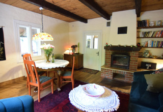 Salon chaleureux du Holiday home Debki en Suède avec cheminée, bibliothèque et table à manger.