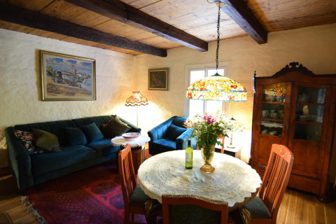Salon du Holiday home «Debki» en Suède avec poutres en bois, canapé, armoire et lampe colorée.