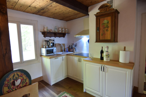 Cuisine chaleureuse du Holiday home «Debki» en Suède avec plafond en bois, armoires blanches et équipements modernes.