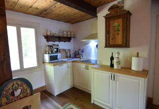 Cuisine chaleureuse du Holiday home «Debki» en Suède avec plafond en bois, armoires blanches et équipements modernes.