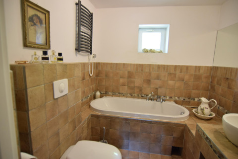 Salle de bain chaleureuse au Holiday home «Debki» en Suède avec baignoire et carrelage rustique.