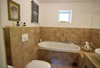 Salle de bain chaleureuse au Holiday home «Debki» en Suède avec baignoire et carrelage rustique.