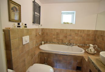 Gezellige badkamer bij Holiday home «Debki» in Zweden met bad, tegels en rustieke decoratie.