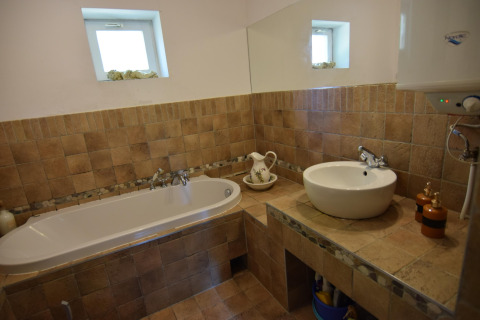 Salle de bain avec baignoire, lavabo et miroir au Holiday home «Debki» en Suède, décor rustique.