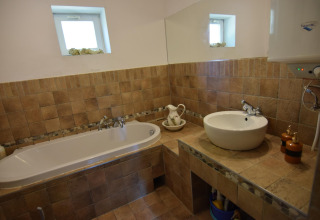 Salle de bain avec baignoire, lavabo et miroir au Holiday home «Debki» en Suède, décor rustique.