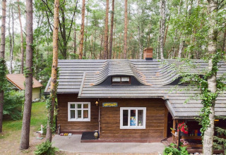 Gîte en bois pittoresque Holiday home «Debki» en Suède, entouré de grands arbres de forêt verdoyante.