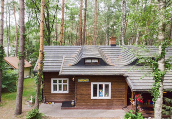 Acogedora cabaña de madera Holiday home «Debki» en Suecia, rodeada de altos árboles y naturaleza.