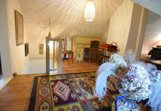 Et hyggeligt loftsrum i Holiday home «Debki» i Sverige med farverigt tæppe og vintage skrivebord.