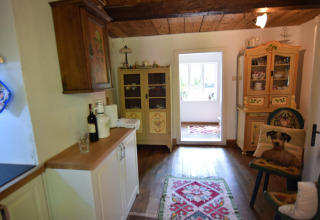 Cuisine chaleureuse avec plafond en bois, meubles colorés et tapis chez Holiday home «Debki» en Suède.