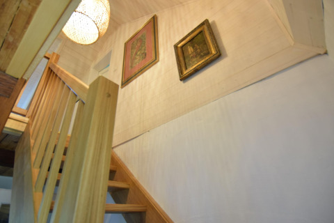 Escalier en bois avec rampe dans la maison de vacances Debki en Suède, vue vers deux tableaux et une lampe.