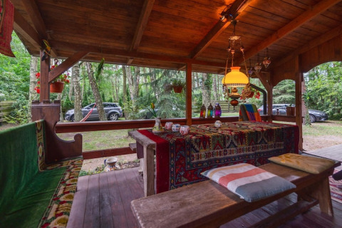 Udendørs siddeområde på Holiday Home «Debki» i Sverige med farverige tekstiler og træborde.