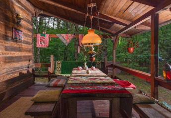 Veranda in legno presso Holiday home «Debki» in Svezia con cuscini colorati e lampada sospesa.
