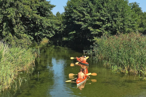 Deux personnes pagaient en kayak sur un canal verdoyant près du Holiday home «Debki» en Suède.