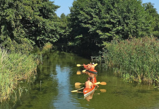 Deux personnes pagaient en kayak sur un canal verdoyant près du Holiday home «Debki» en Suède.