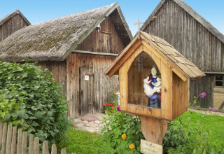 Maison suédoise typique au toit de chaume et oratoire en bois dans le jardin à Holiday home «Debki».