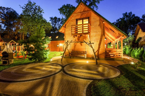 Aftenbillede af træhytte med terrasse, gårdhave og gynge ved Holiday complex Pobierowo-Doppelhaus i Tyskland.