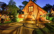 Foto nocturna de cabaña de madera con terraza, patio y columpio en Holiday complex Pobierowo-Doppelhaus en Alemania.