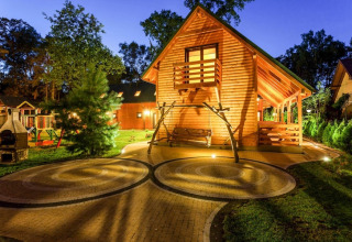 Aftenbillede af træhytte med terrasse, gårdhave og gynge ved Holiday complex Pobierowo-Doppelhaus i Tyskland.