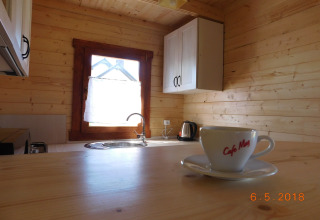 Cucina luminosa in una baita di legno con tazza di caffè sul tavolo alle Holiday homes di Swinoujście, Germania.