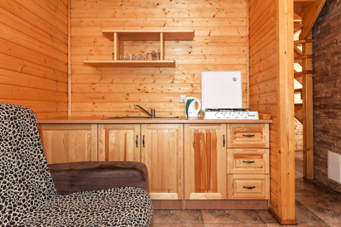 Houten kitchenette in Holiday complex Pobierowo-Doppelhaus met fornuis, spoelbak en luipaardstoel.
