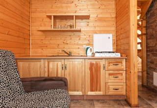 Træbeklædt tekøkken i Holiday complex Pobierowo-Doppelhaus med komfur, vask og leopardmønstret stol.