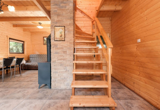 Interieur van vakantiecomplex Pobierowo-Doppelhaus 4 en 2 met houten muren, stenen trap en eetgedeelte.