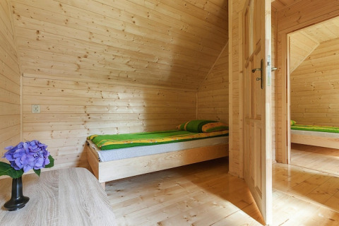 Cozy wooden bedroom at Holiday complex Pobierowo-Doppelhaus 4 and 2 with single bed, green bedding and flower.
