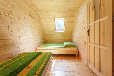 Bright wooden bedroom with two single beds, green bedspreads, and skylight in Holiday complex Pobierowo-Doppelhaus 4 und 2.