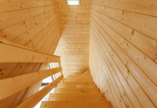 Indoor wooden staircase at Holiday complex Pobierowo-Doppelhaus 4 and 2 lodge, with light wood panels.