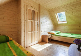 Bright wood-paneled room with two single beds and skylight window at Holiday complex Pobierowo-Doppelhaus 4 and 2.