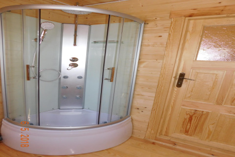 Moderne glazen douchecabine en houten deur in een vakantiehuis in Swinoujście, Duitsland.