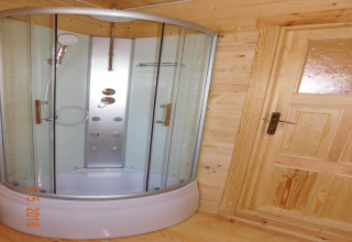 Moderne glazen douchecabine en houten deur in een vakantiehuis in Swinoujście, Duitsland.