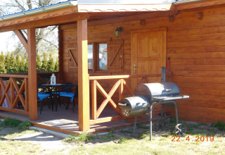 Træhytte med terrasse, grill og havemøbler i solen, feriehus til 5 personer i Swinoujście, Tyskland.