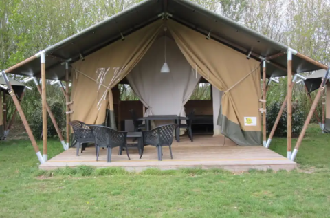 Safaritent op een houten terras bij Boerencamping Swarthoeve in Noord-Holland met tuinstoelen en tafel.