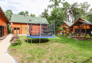 Outdoor area with trampoline, playhouse, and wooden houses at Holiday complex Pobierowo-Doppelhaus 4 and 2.