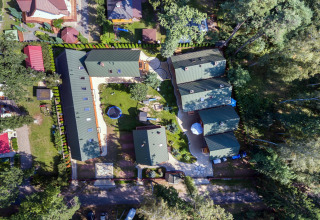Luchtfoto van Holiday complex Pobierowo-Doppelhaus 4 en 2 met groene daken, tuinen en omliggende bomen.