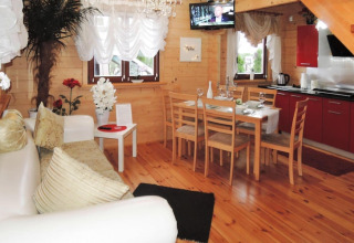 Accogliente soggiorno e cucina in una casa vacanze a Rewal per 6 persone, con pareti in legno.