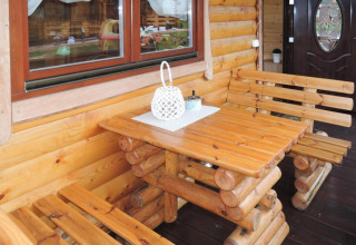Houten tafel en banken in een gezellig vakantiehuis voor zes personen in Rewal, ideale sfeer.