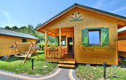 Chalet d'été pour quatre personnes à Mielno, Danemark, avec véranda, balançoire et volets verts.