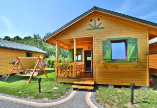 Zomerhuisje voor vier personen in Mielno, Denemarken, met houten schommel, veranda en groene luiken.