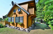 Casa vacanza in legno per 6 persone a Kołobrzeg, Danimarca, con persiane verdi e giardino.