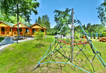 Legeplads med klatrestativ og grønne omgivelser foran sommerhytter for 4 personer i Mielno, Danmark.
