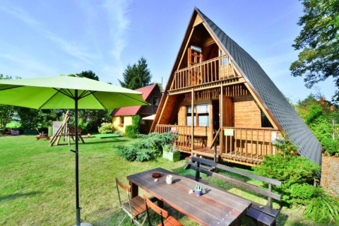 Zomerhuis TYPE B van 70 m2 in Osieki, Denemarken, met ruime tuin, tuintafel en groene parasol.