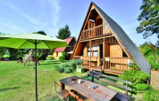 Zomerhuis TYPE B van 70 m2 in Osieki, Denemarken, met grote tuin, buitentafel en groene parasol.